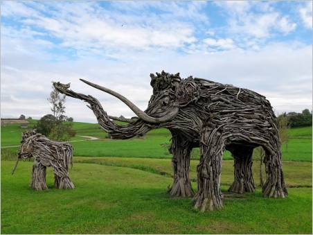 Großes und kleines Mammut aus einheimischem Schwemmholz auf der Wiese